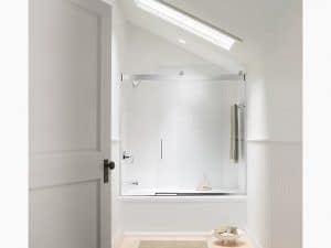 Picture of a beautiful bathtub enclosure in a white bathroom with a slanted roof and a skylight.